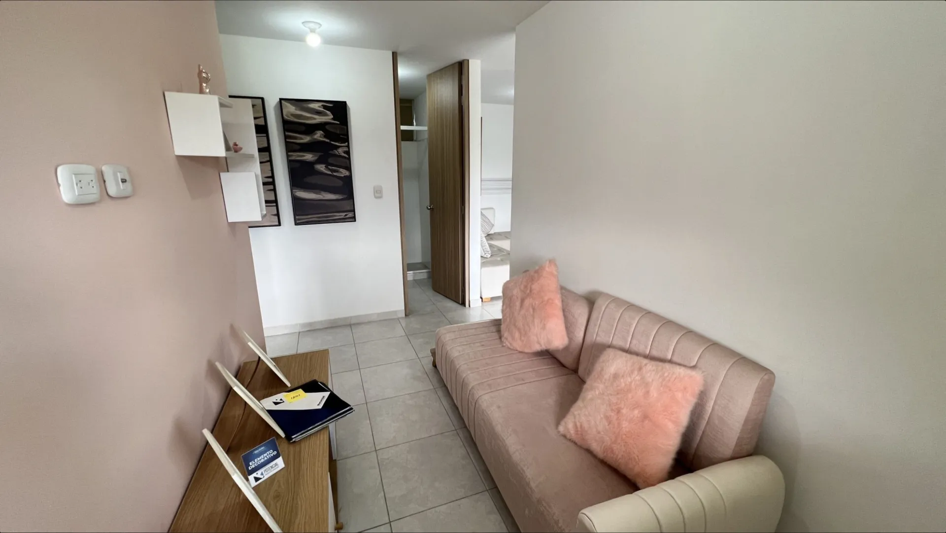 Rincón de estar en el pasillo del apartamento modelo de San Juan de la Cuesta, con sofá para descansar