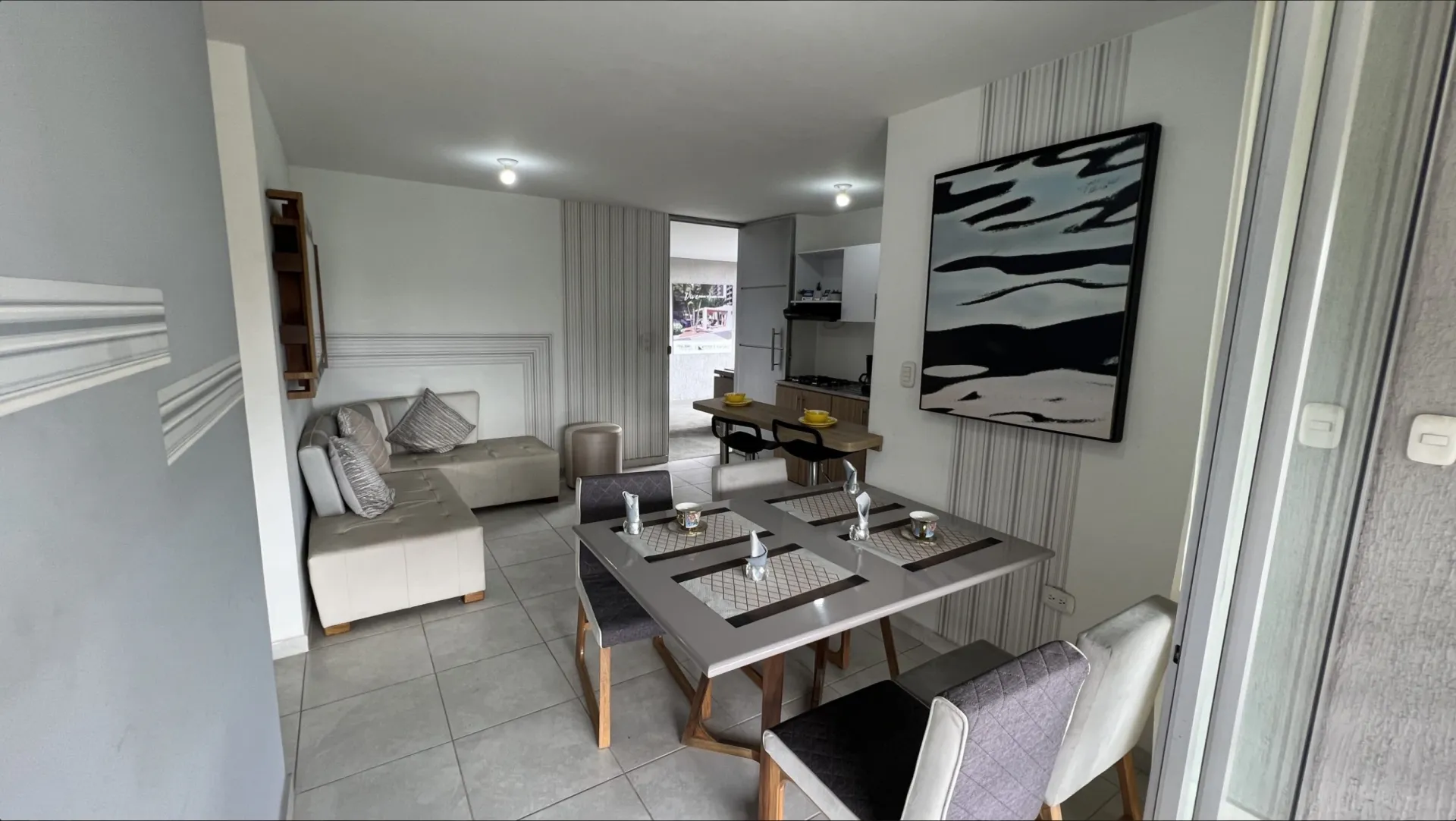 Sala-comedor del apartamento modelo de San Juan de la Cuesta con sofá, mesa de comedor y salida al balcón